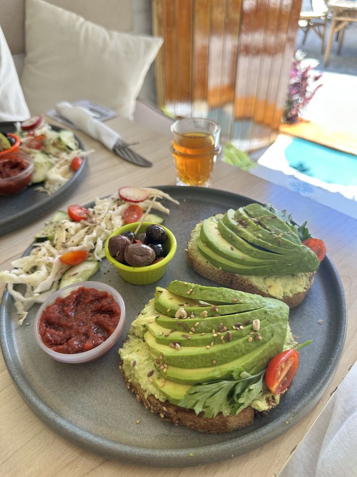 Avocado toast : pain complet, avocat en éventail, graines et tomate cerise, avec salade et thé