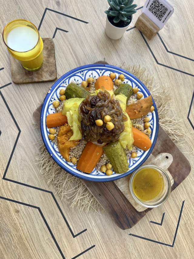 Couscous aux légumes : semoule, carottes, courgettes, pois chiches et oignons confits, avec jus d'orange